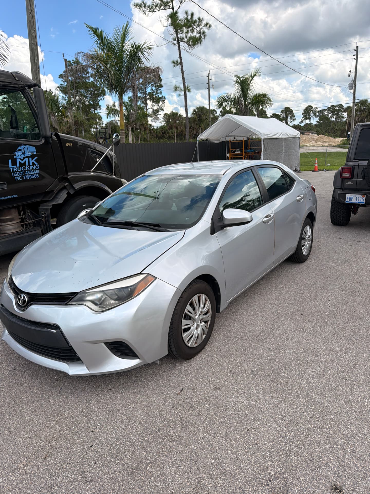 Silver 2014 Toyota Corolla rental car parked on the DriveLine Rentals lot